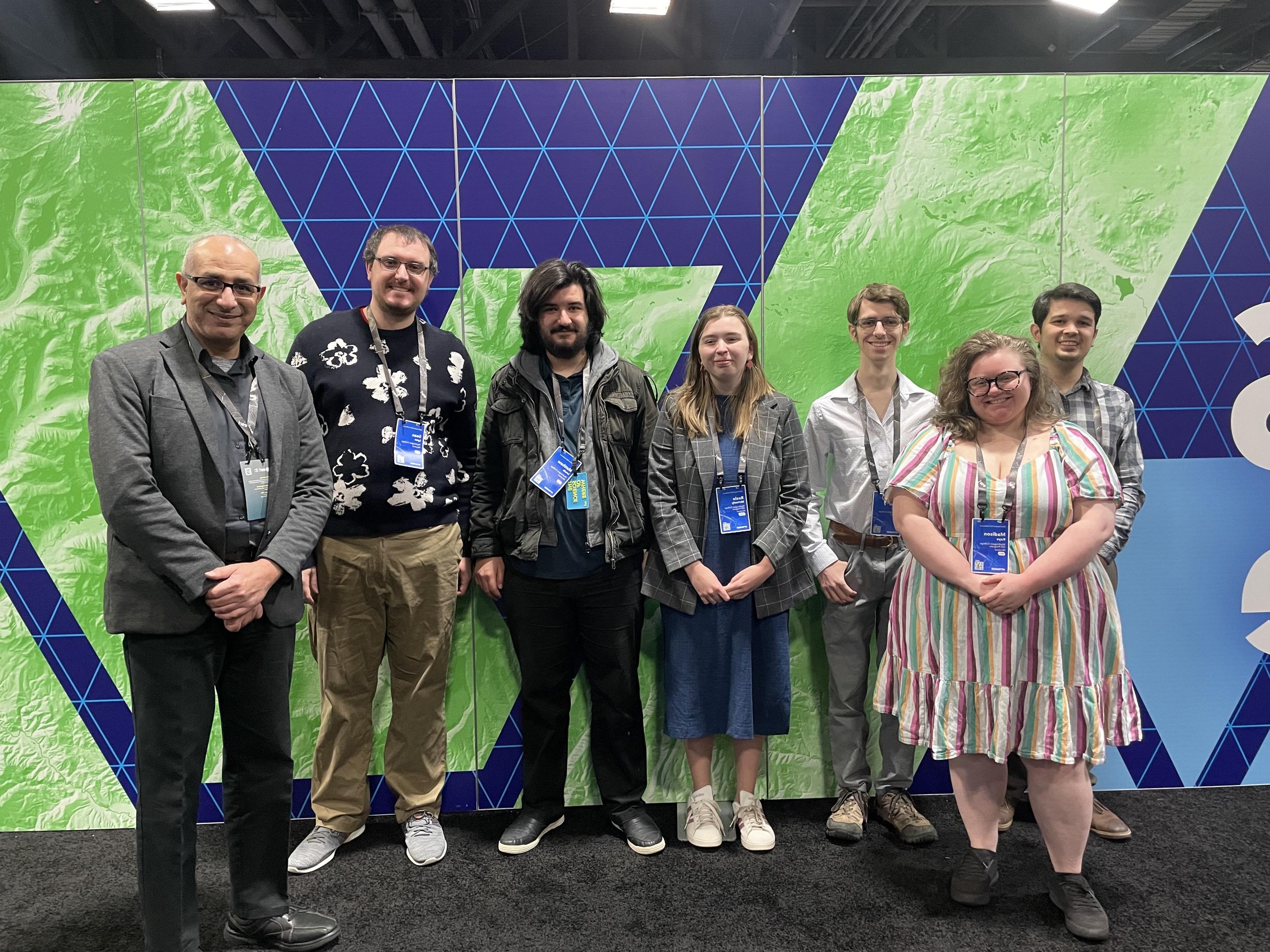 GIS staff in front of a map graphic